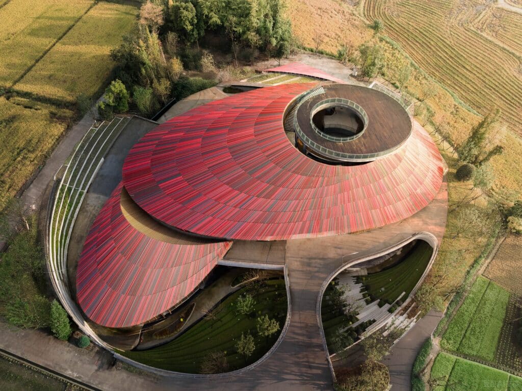 High-angle aerial shot of Douban Museum illustrating the bean-shaped roof and the surrounding agricultural fields.