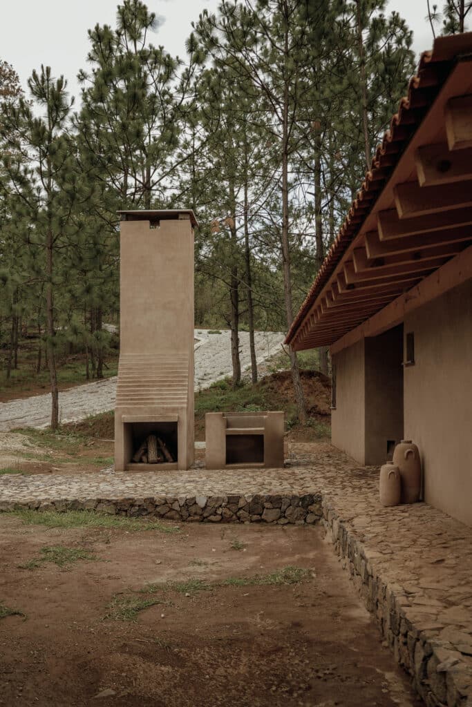 Outdoor stone fireplace and leisure area connected to the cabin by a stone platform.