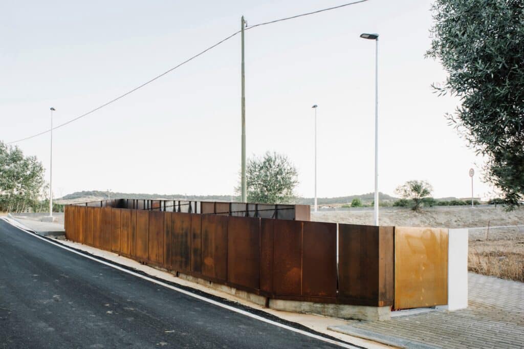 The architectural intervention along the road showing the transition from asphalt to the Corten steel landscape element.