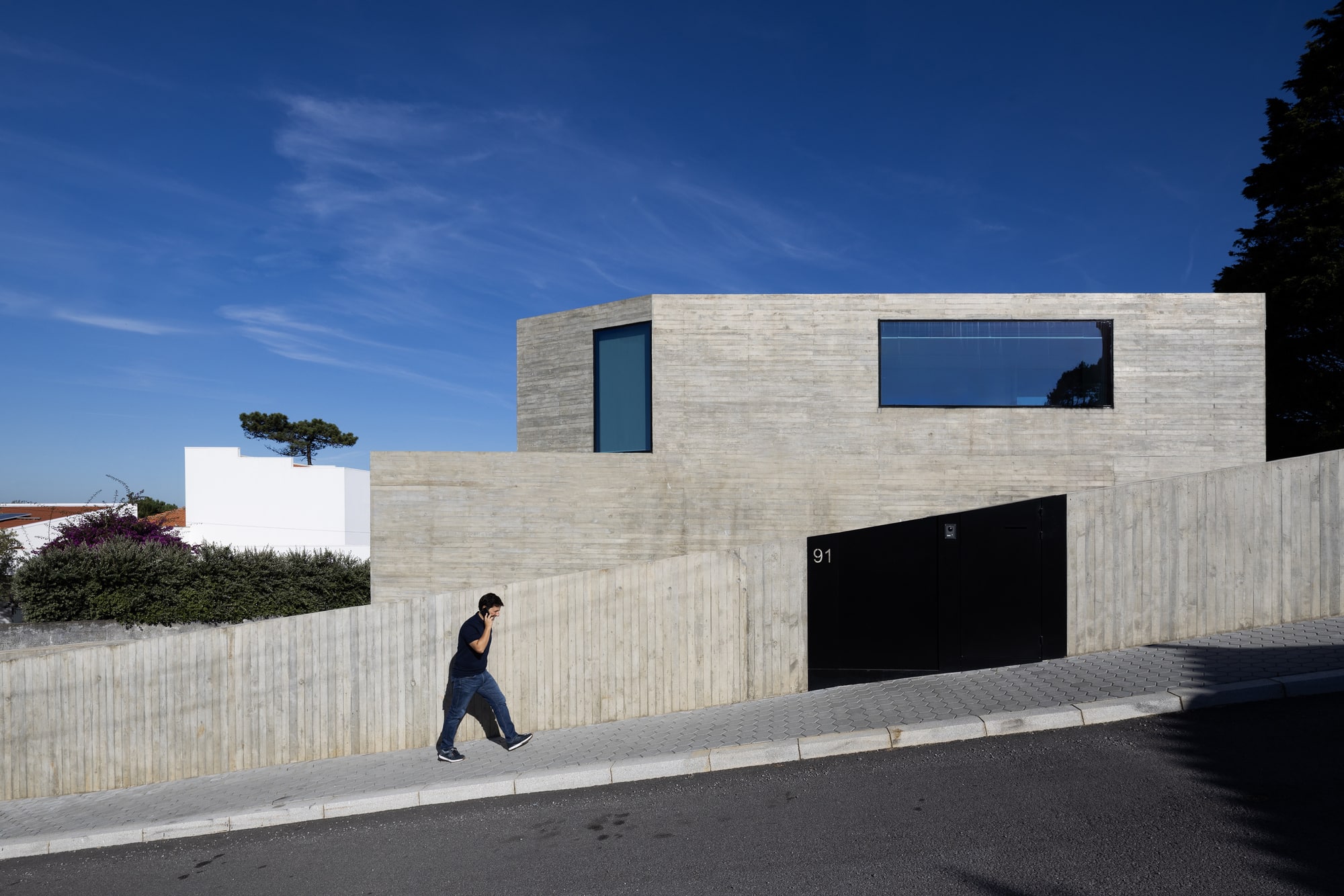Exterior street-facing facade of Villa Nova de Gaia House featuring exposed concrete walls and minimal window openings for privacy.