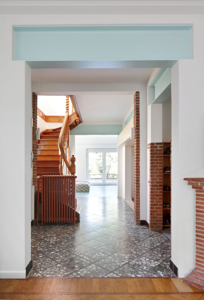Internal view from the entrance showing the visual continuity towards the garden through an open-plan layout.
