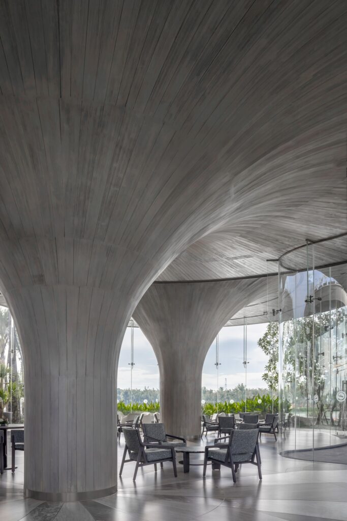 Detailed interior shot of textured concrete columns and minimalist furniture at Lotus Club.