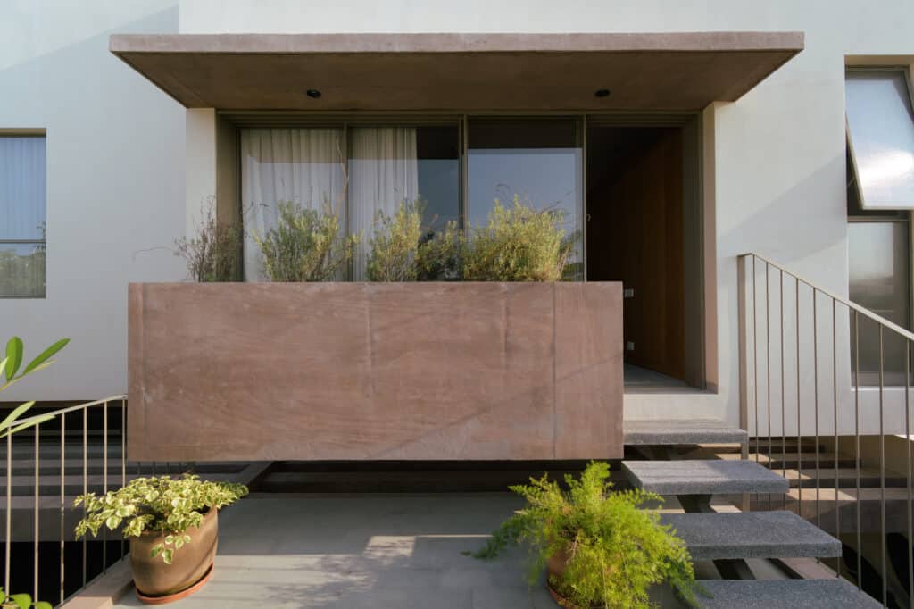 Close-up of pigmented concrete planters and grey marble stairs in a modern Mexican home.