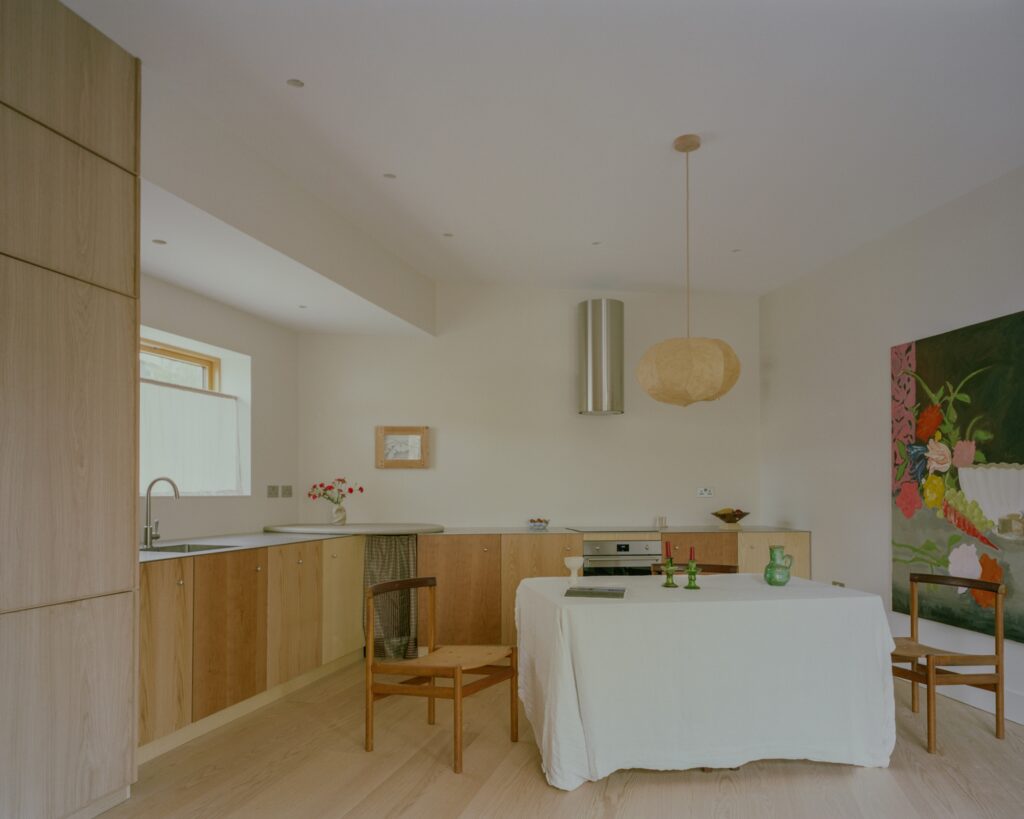 Modern open-plan kitchen and dining area in Runda House with light wood cabinetry and minimalist furniture.