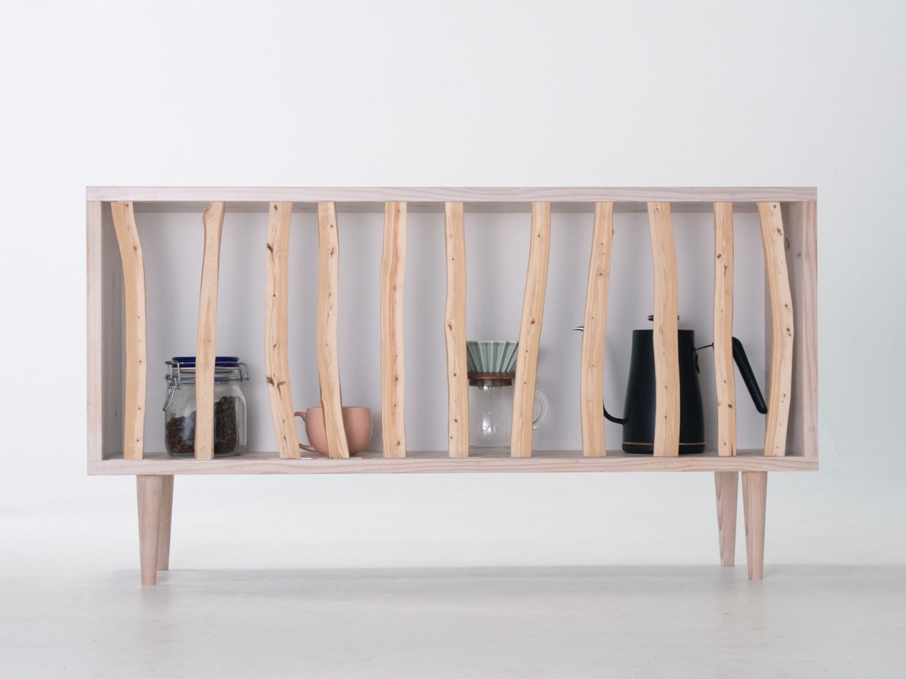 Front view of the Hayashi Cabinet by Taishi Sugiura featuring sliding Japanese cypress branches with coffee accessories inside.