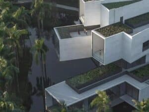 Aerial close-up of the Pearl River Delta Wetland Museum featuring stacked concrete tubes and rooftop water gardens.