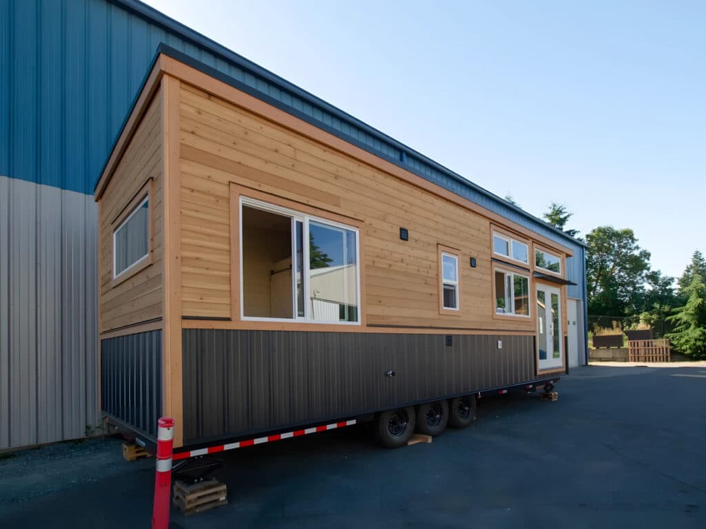 Side profile of the Dove tiny house showing its 10-foot width expansion and large windows for natural lighting.
