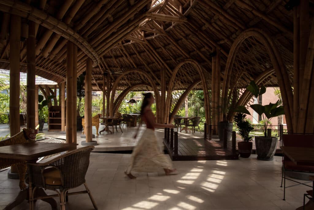 Wide interior shot of Guna restaurant featuring A-frame bamboo arches and open-plan dining area.