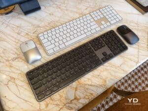 Full-size Satechi Slim EX3 keyboards and wireless mice in silver and space gray on a marble table.