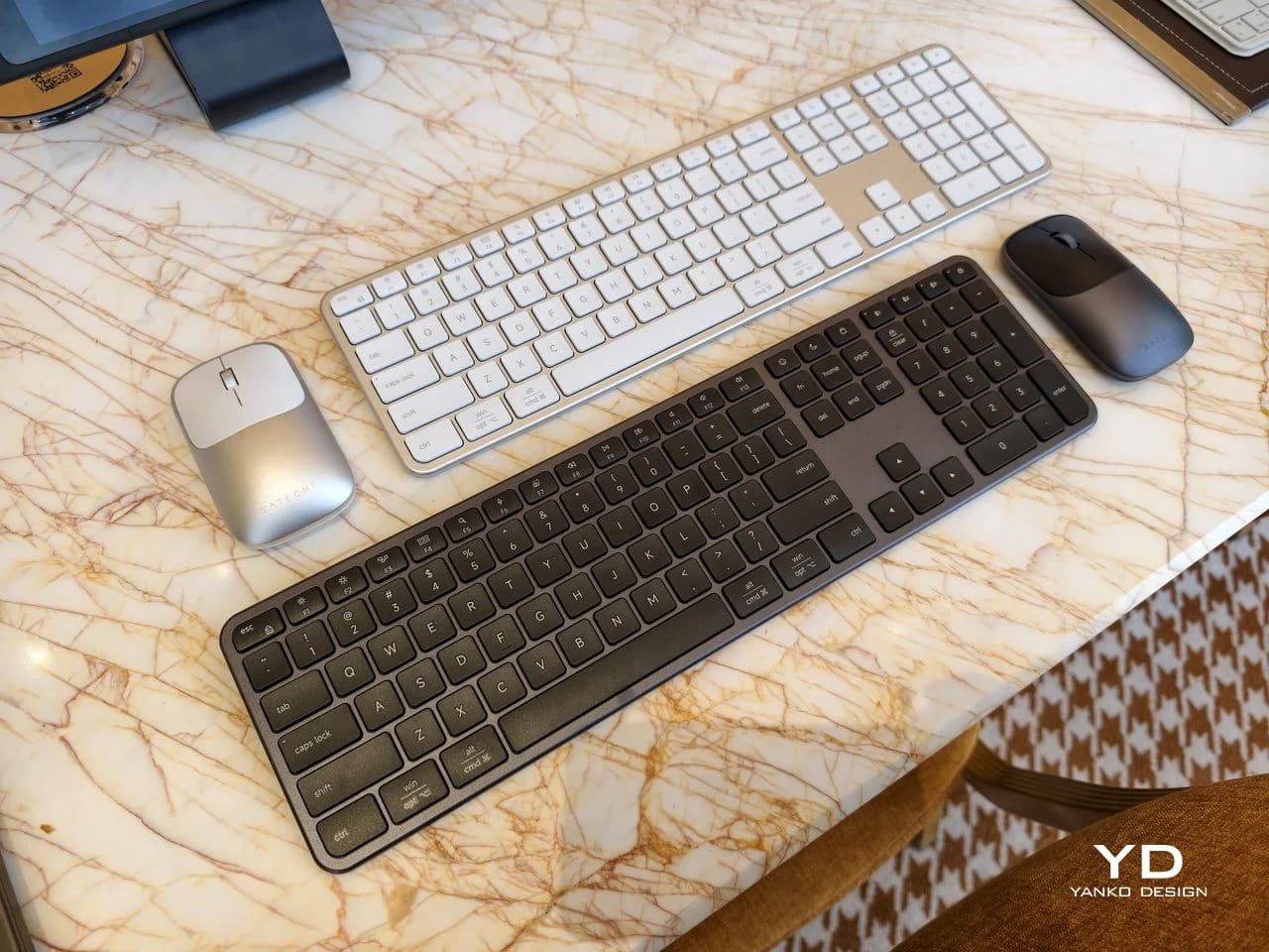 Full-size Satechi Slim EX3 keyboards and wireless mice in silver and space gray on a marble table.