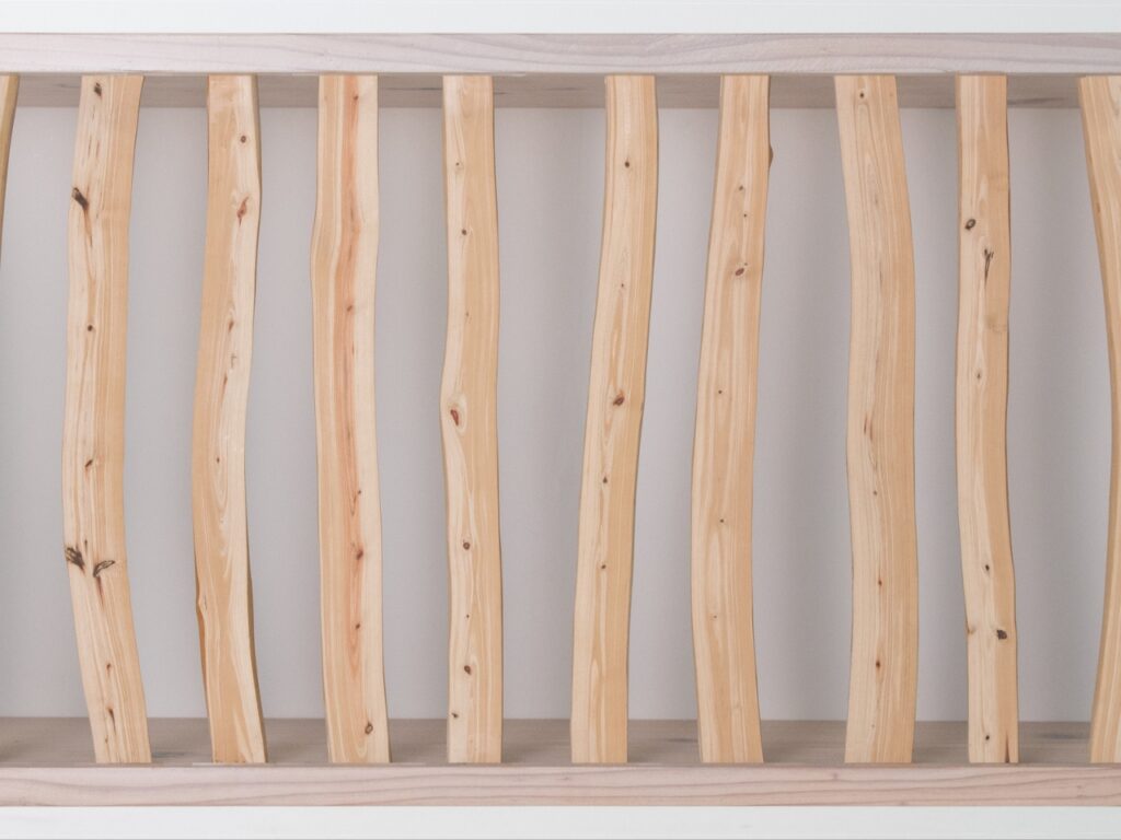 Close-up detail of the organic texture and curves of Japanese cypress branches on the Hayashi Cabinet facade.