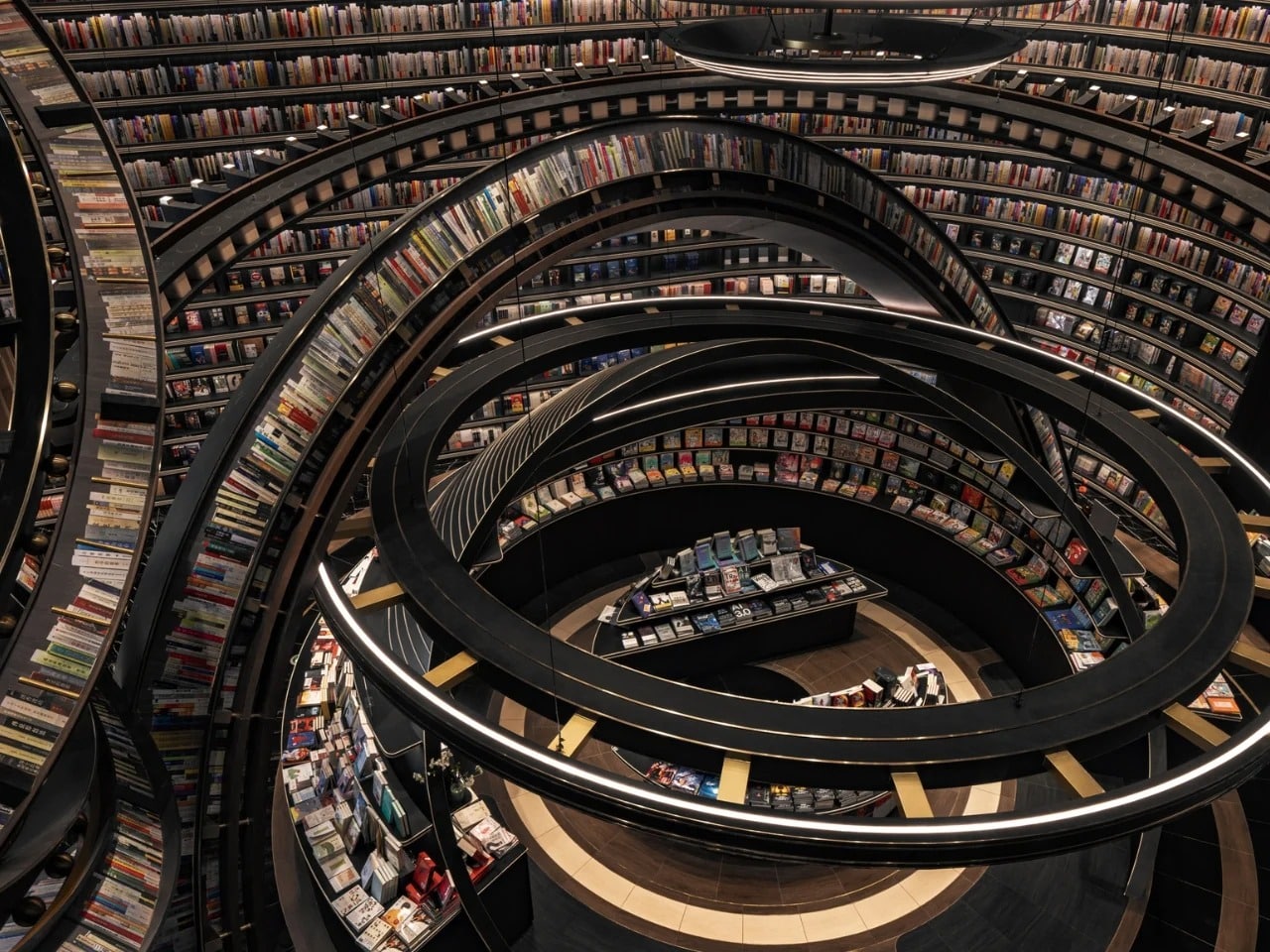 Top view of Huai’an Zhongshuge library featuring circular black bookshelves arranged in concentric rings resembling planetary orbits.