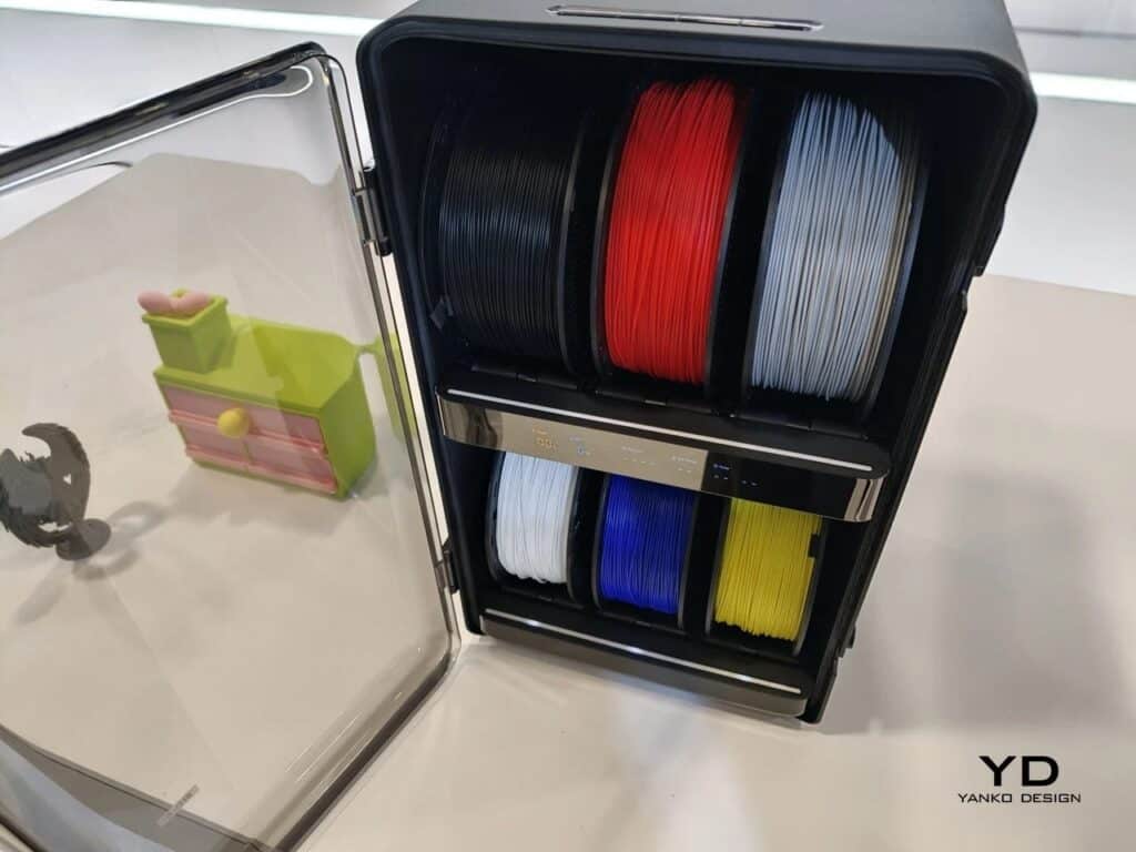 Front view of the AtomForm filament management system with two rows of filament spools behind a transparent door.
