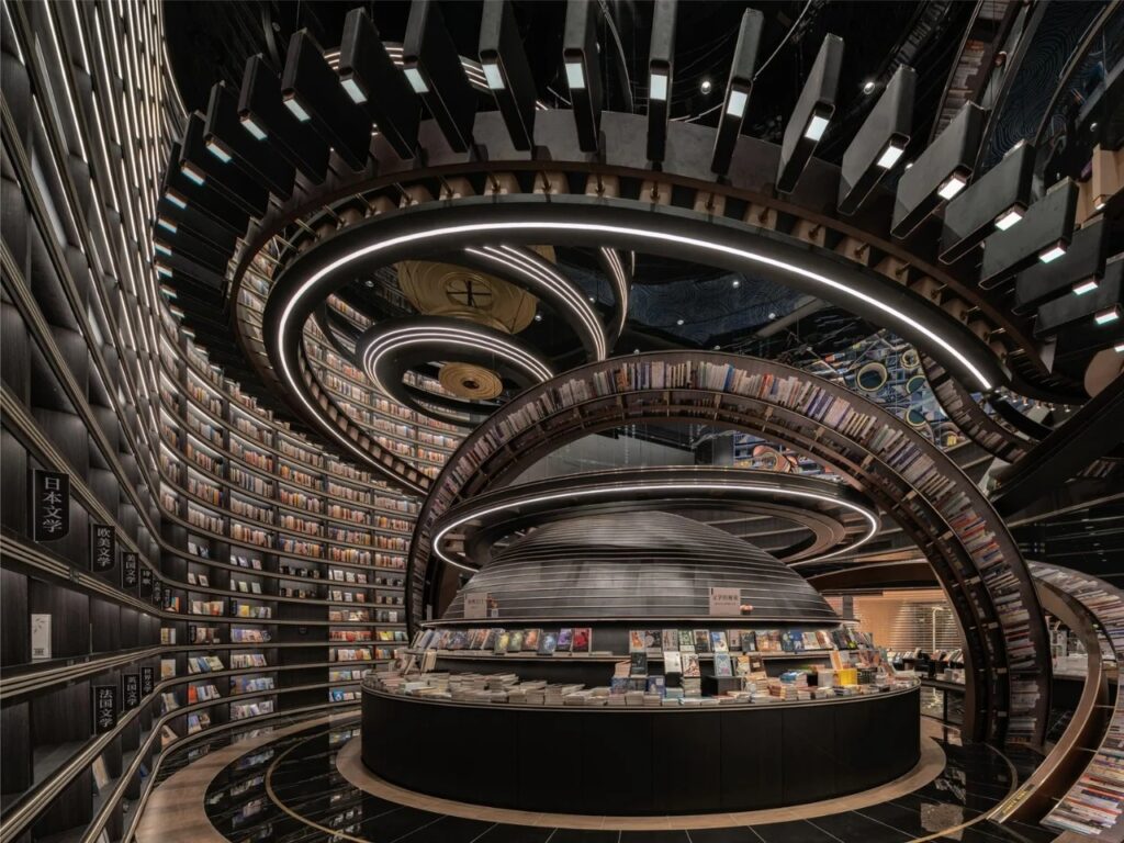 Wide shot of a circular reading hall in Huai&rsquo;an Zhongshuge with a large central hemispherical display and illuminated ring shelves.