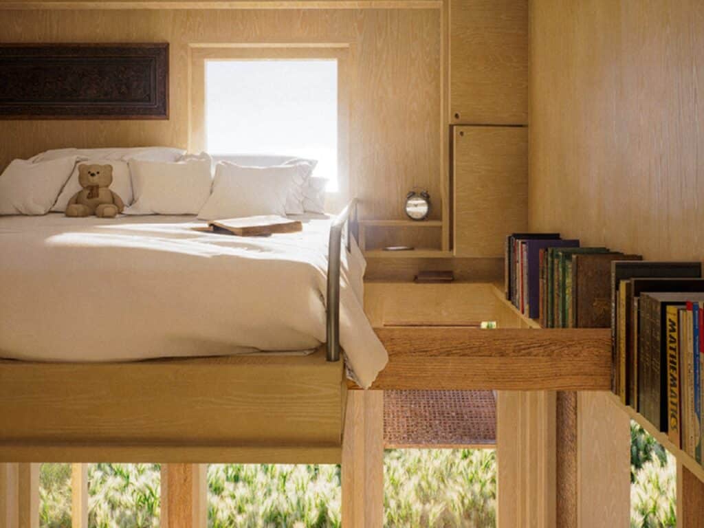 Close-up of a cozy loft bed with wooden bookshelves and a small window in a sustainable tiny house.