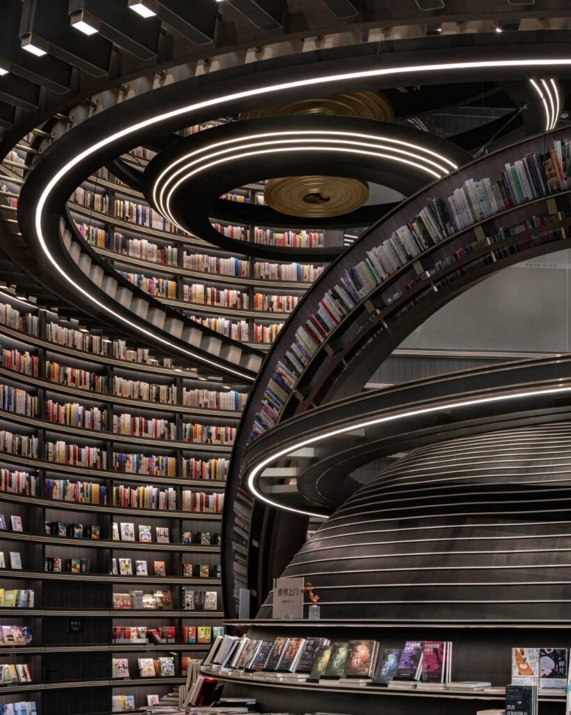 Close-up of spiraling black bookshelves with integrated LED lighting and stacked books in Huai&rsquo;an Zhongshuge.