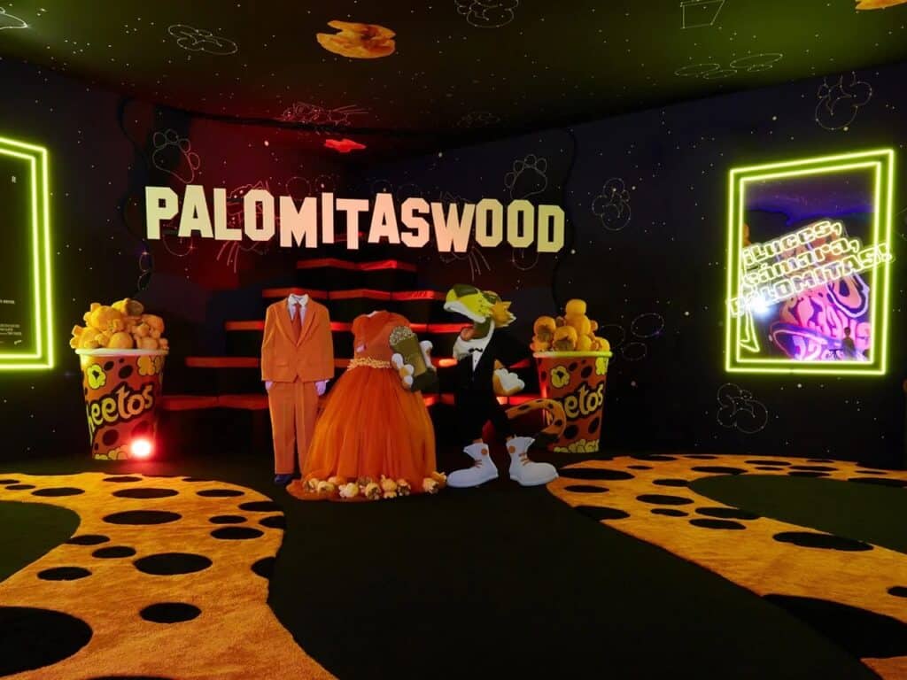 "Palomitaswood" room featuring a Hollywood-inspired theme with starry ceiling, orange suits, and large popcorn buckets.