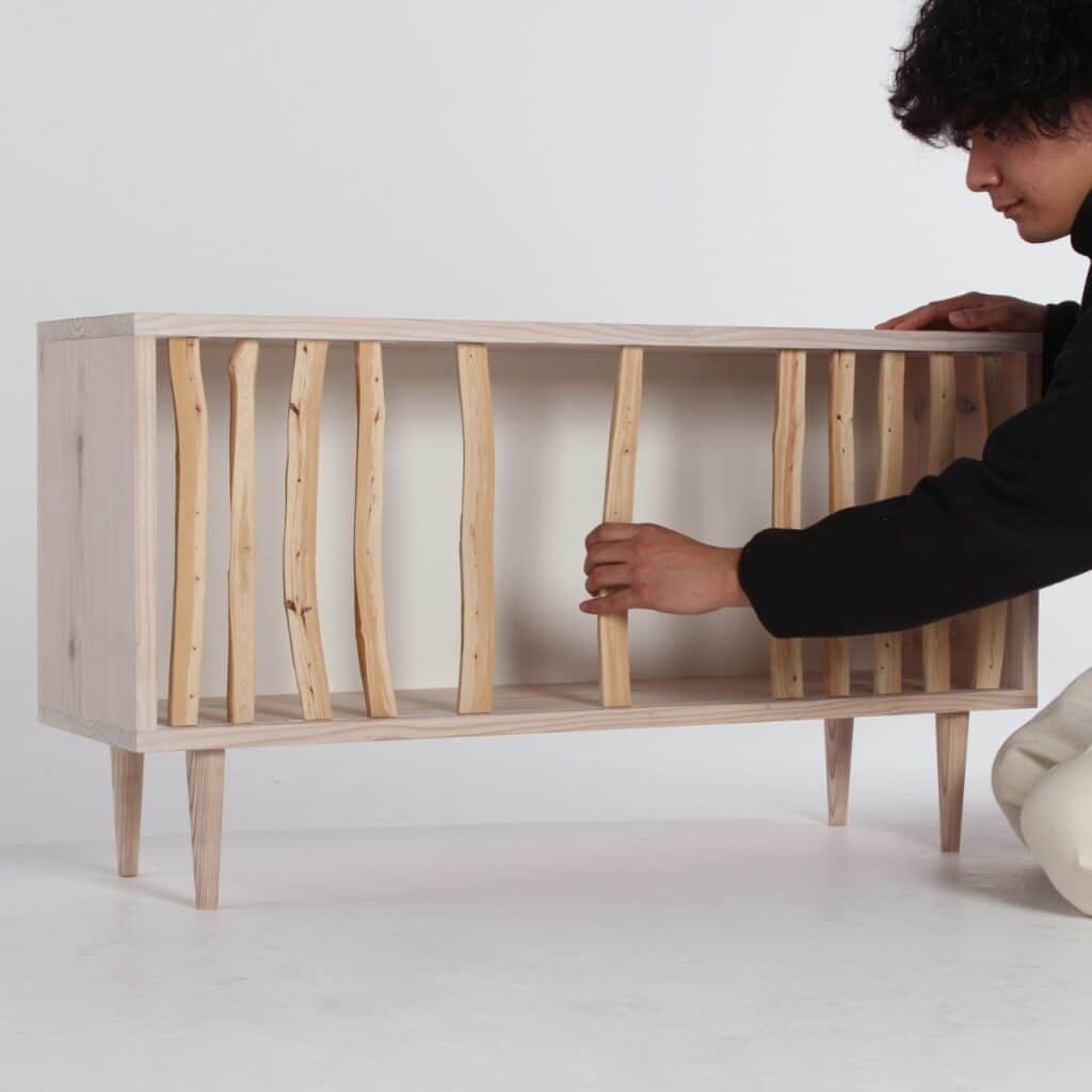 Designer Taishi Sugiura demonstrating the sliding branch mechanism of the Hayashi Cabinet.