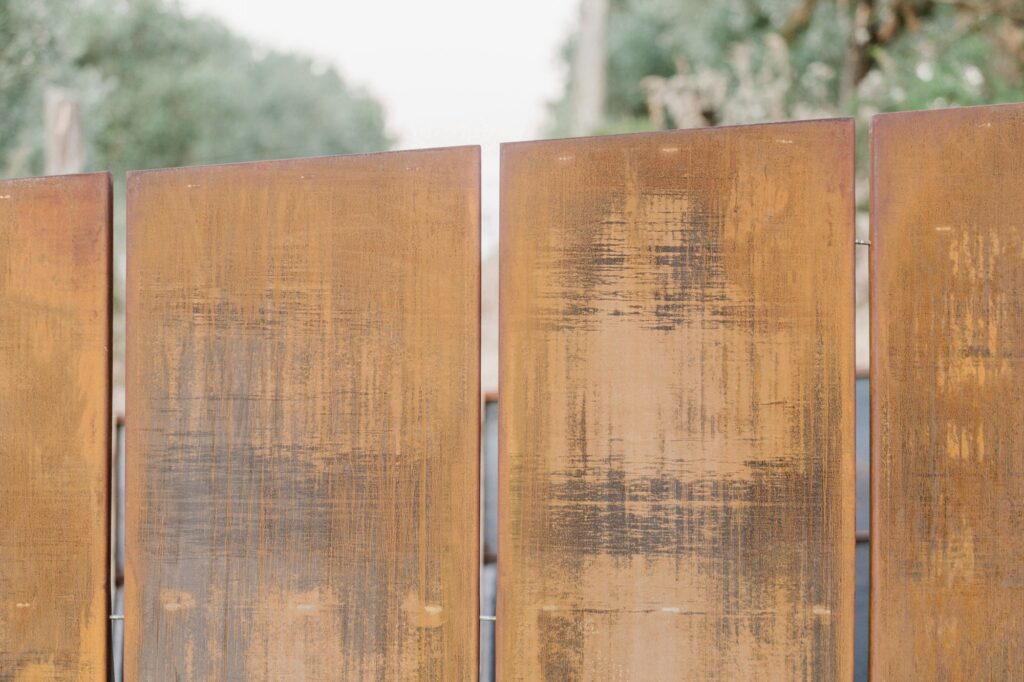 A detailed close-up of the oxidized texture and vertical joints of the Corten steel panels.