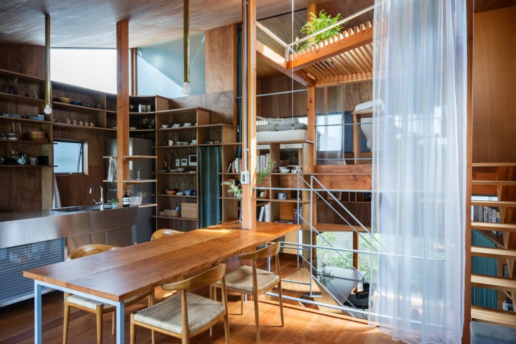 Warm wooden interior of a Tokyo home featuring high ceilings, natural light, and a view of interconnected living platforms.