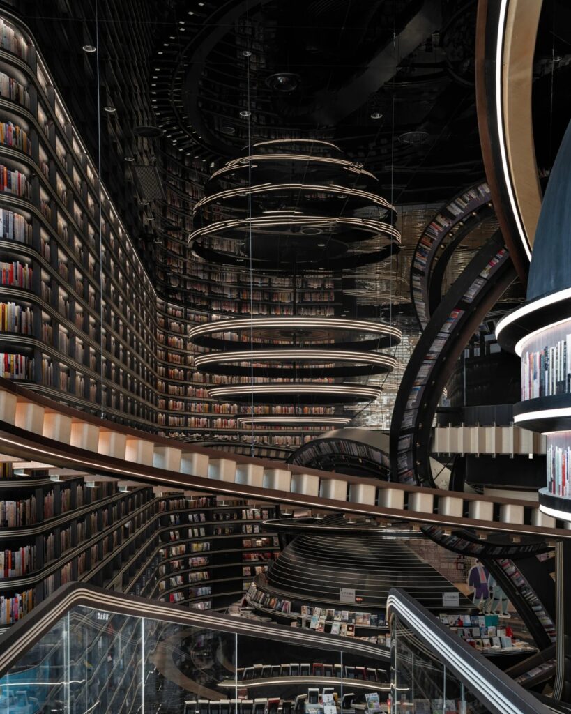 Perspective view from an upper balcony showing the vast scale of the library and the suspended spherical bookshelves.