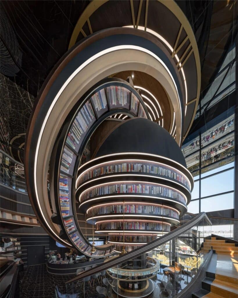 Dramatic interior view of a towering, globe-shaped bookshelf structure in Huai&rsquo;an Zhongshuge next to a large window.