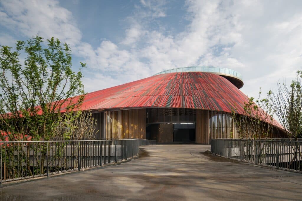 The main entrance path of Douban Museum leading under the expansive red roof toward the central courtyard.