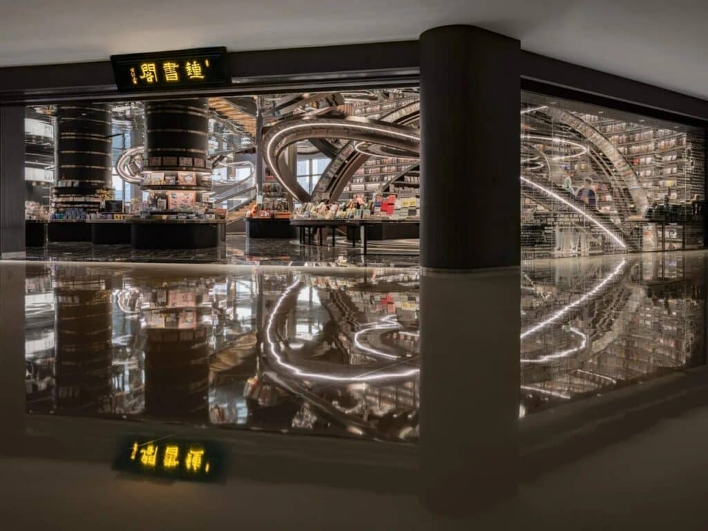 Exterior entrance view of Huai&rsquo;an Zhongshuge library with reflective glass and glowing signage in a modern urban setting.