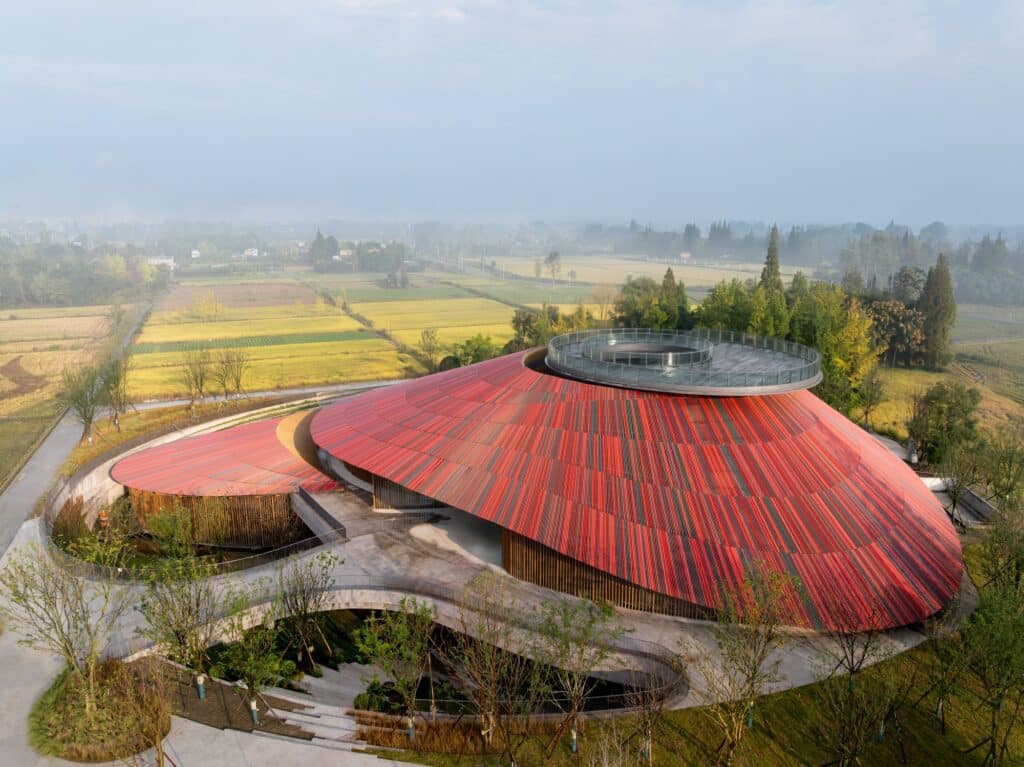 Wide view of the sunken courtyard at Douban Museum showing the underground functional spaces and the circular terrace.