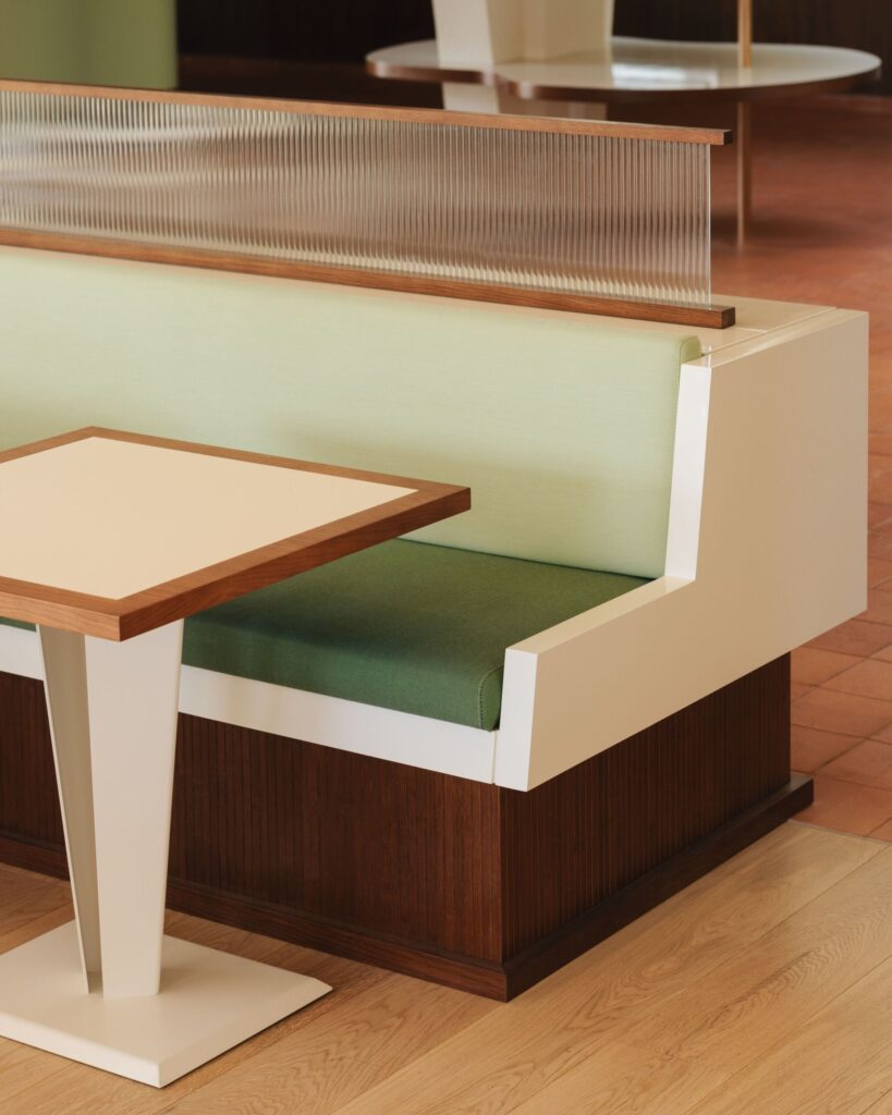 Close-up of custom-designed seating booth with green upholstery and ribbed glass partition at Le Belv&eacute;d&egrave;re.