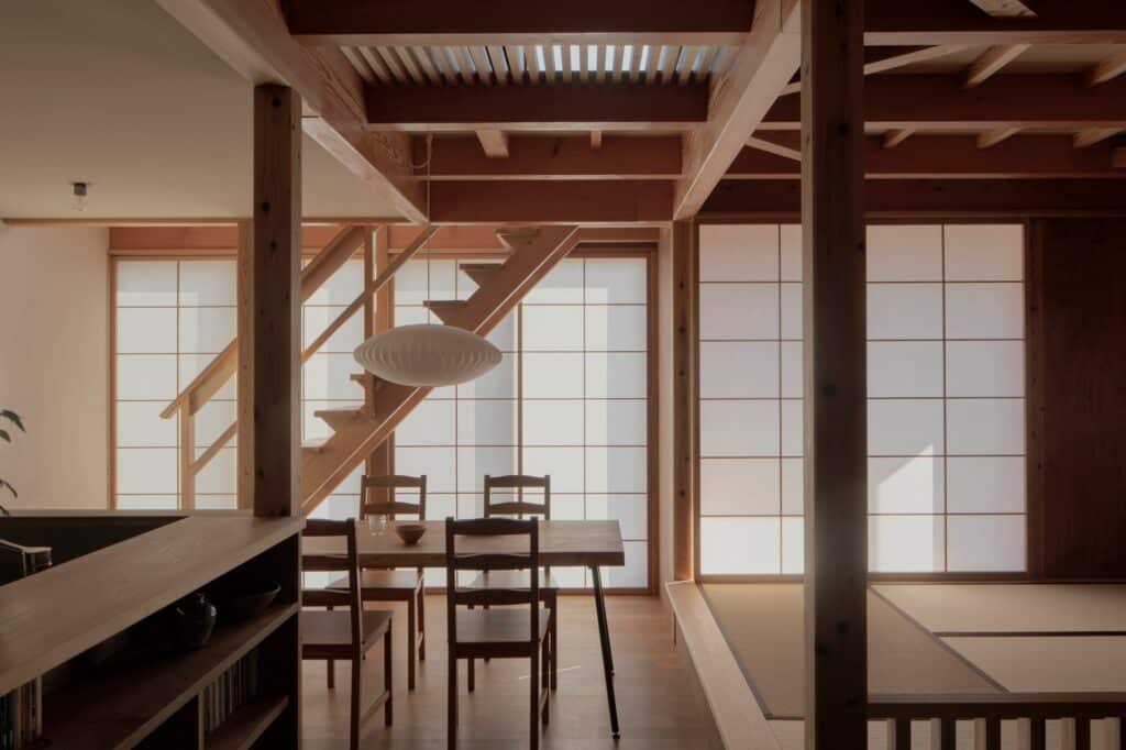 Open-plan interior showing the relationship between the staircase, dining table, and the Japanese room.