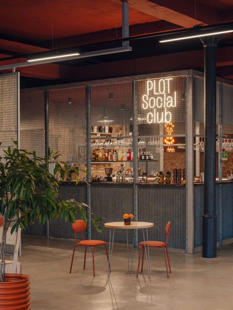 Plot Social Club bar area in Grid Arthub with neon signage and wire mesh partitions.