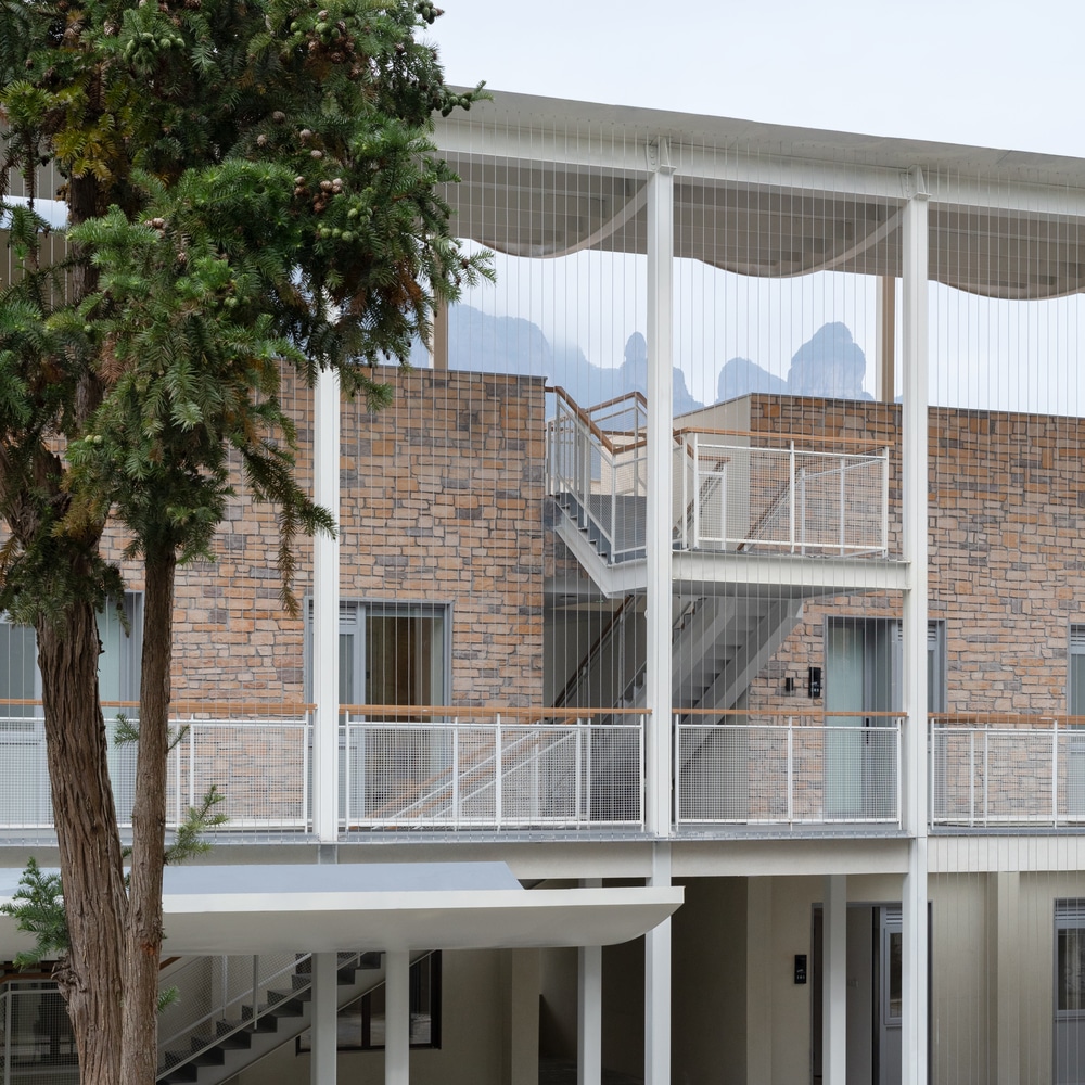 Close-up of a renovated steel and wood staircase at Qingyi Lodge, replacing the original school stairs.