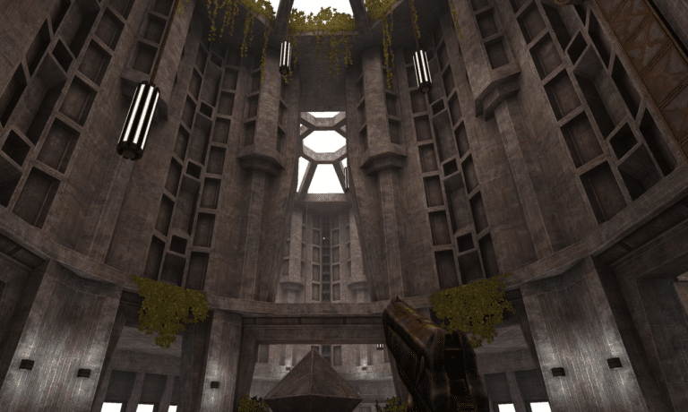 A first-person perspective in a video game showing a massive, circular concrete hall with brutalist architecture, hanging vines, and a futuristic weapon held in the foreground.