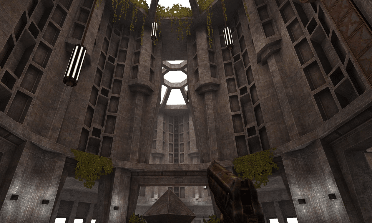 A first-person perspective in a video game showing a massive, circular concrete hall with brutalist architecture, hanging vines, and a futuristic weapon held in the foreground.