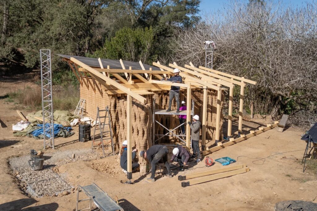 Students collaborating on a large-scale timber prototype, showcasing hands-on architectural education at IAAC.