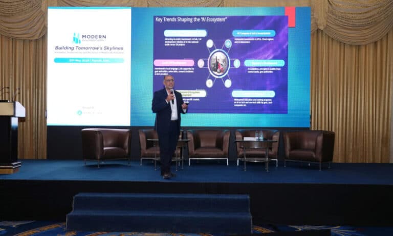 Attendees listen to a panel discussion in a large, modern auditorium during a professional conference.