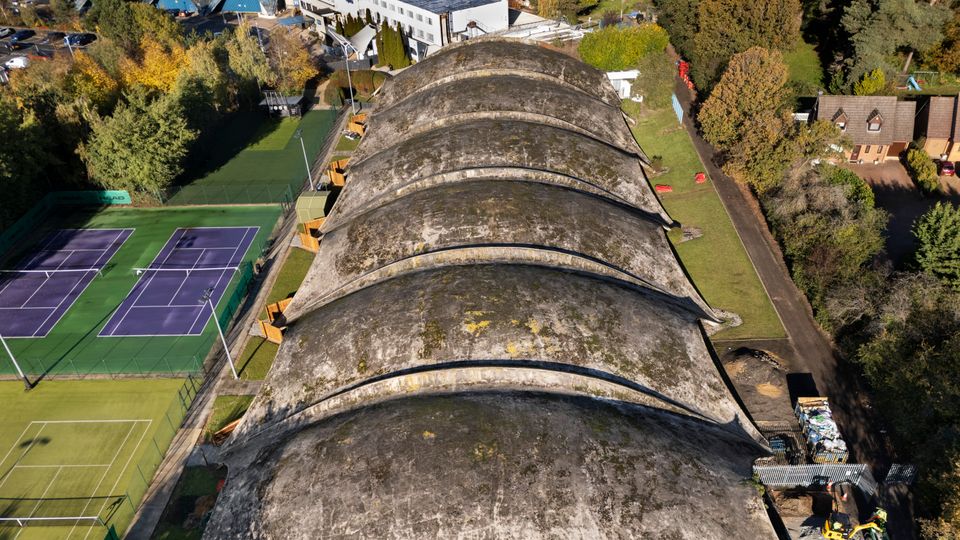 The unique concrete shell roof of the Norwich Sports Village, a key work by Heinz Isler, showing its curved form and moss growth over time.