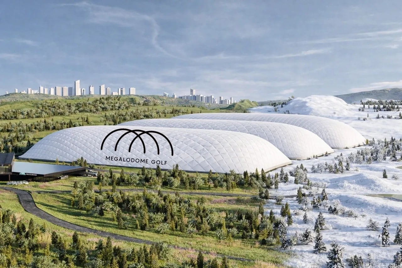 Wide aerial view of the Megalodome Indoor Golf Course facility, showing three large white domes under a clear sky.