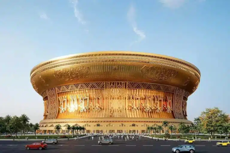 The gold-colored fa&ccedil;ade of the Largest Stadium in Vietnam, designed to resemble a Dong Son bronze drum with intricate Lac bird motifs and geometric reliefs.