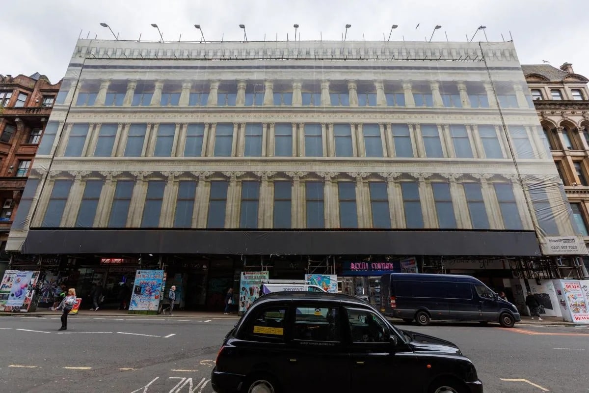 A nighttime rendering of the revived Egyptian Halls in Glasgow, showcasing its illuminated historic facade and a new rooftop pavilion.