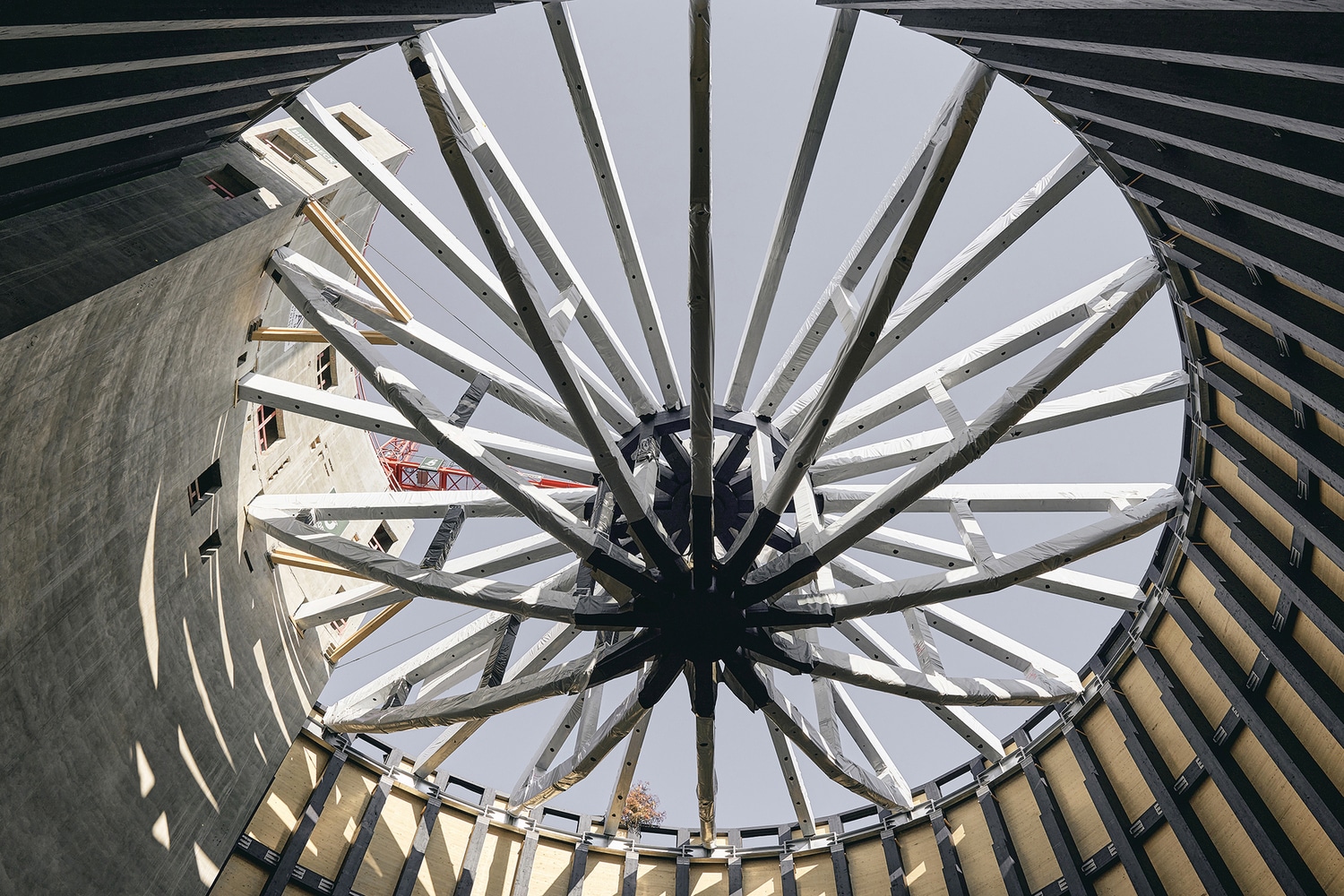 A multi-story residential building featuring a prominent timber frame and colorful recessed balconies, showcasing modern Timber Construction.