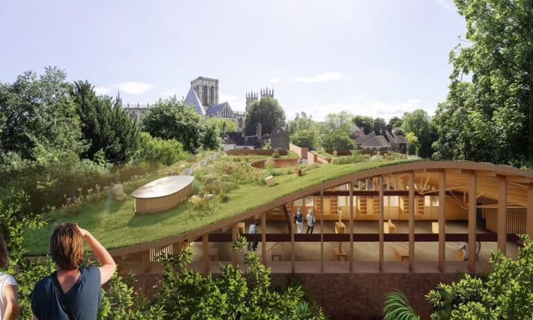 A wide shot of the Park Hill redevelopment, a RIBA Yorkshire Awards finalist, showing the iconic brutalist concrete frame with new colorful glazed panels and timber detailing under an overcast sky.