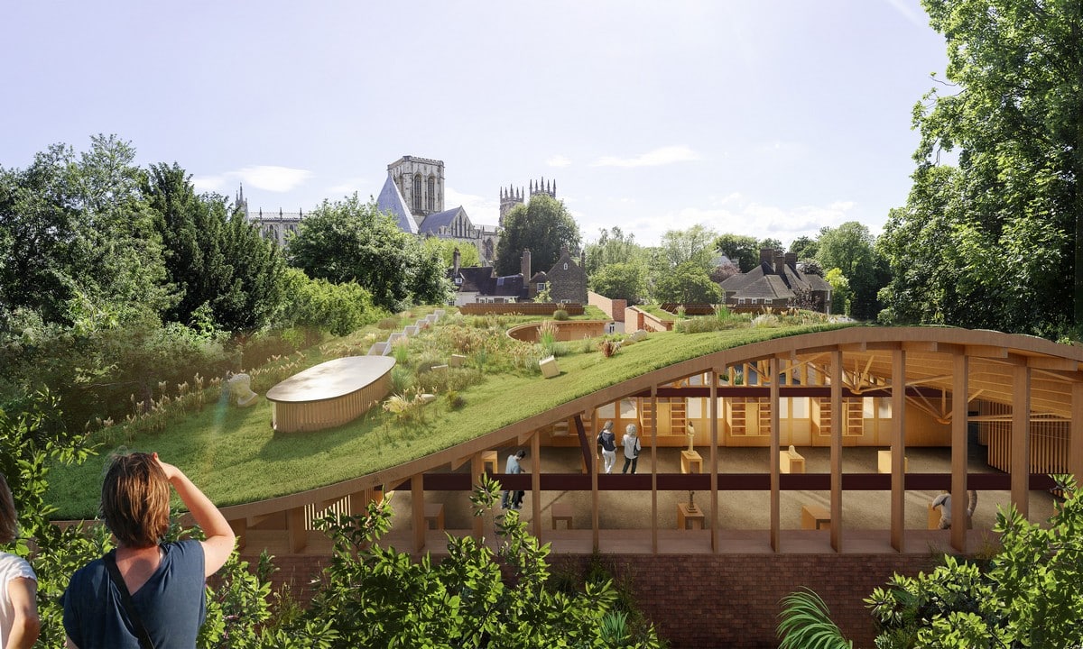 A wide shot of the Park Hill redevelopment, a RIBA Yorkshire Awards finalist, showing the iconic brutalist concrete frame with new colorful glazed panels and timber detailing under an overcast sky.