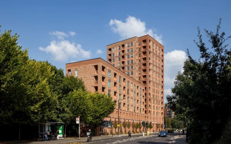 Exterior view of the new Brentford residential development featuring multi-unit brick apartment blocks against a blue sky.