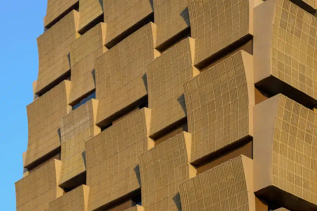 Close-up detail of the curved foam concrete modules on the Cielo Tower facade, showing the porous vertical slit patterns.