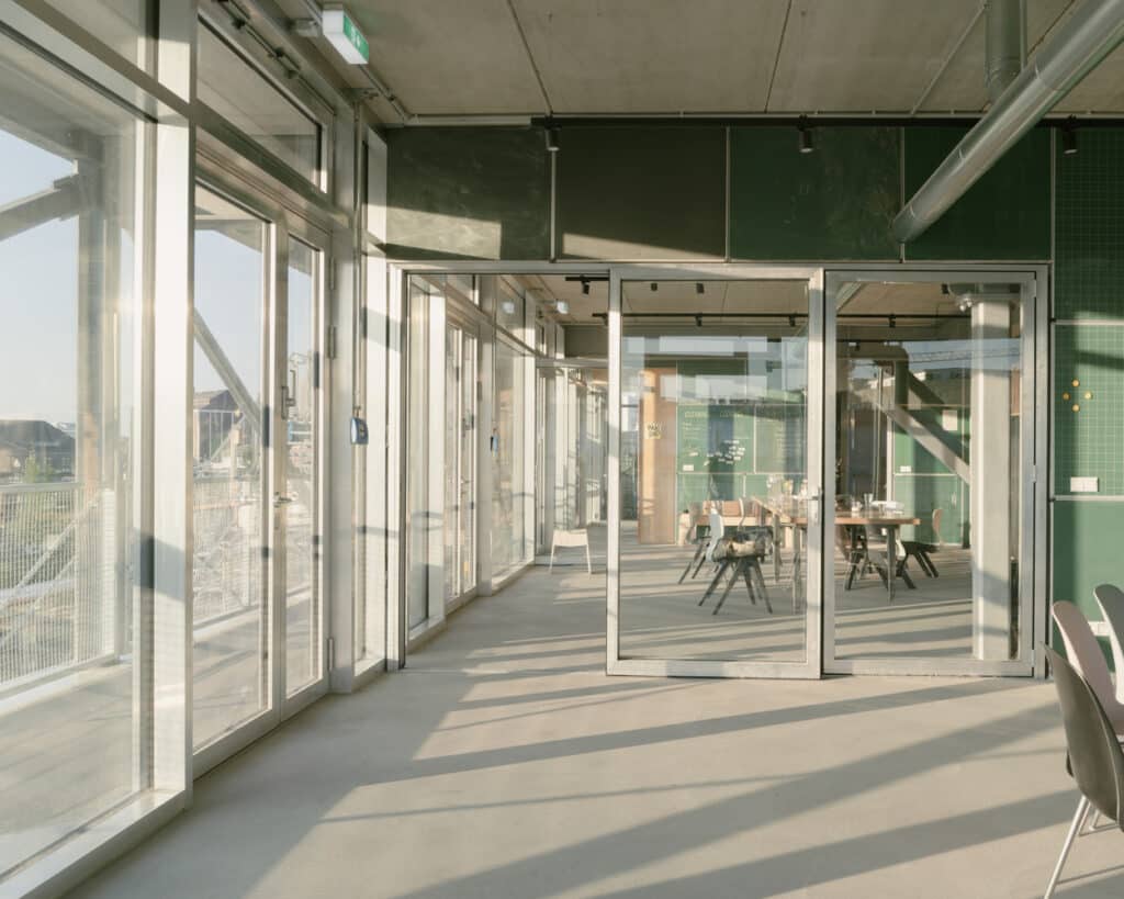 منظر خارجي لمركز ZK/U في برلين، وهو مثال على إعادة الاستخدام المعماري، حيث يظهر الهيكل الجديد خفيف الوزن وهو يغلف المبنى الأصلي.