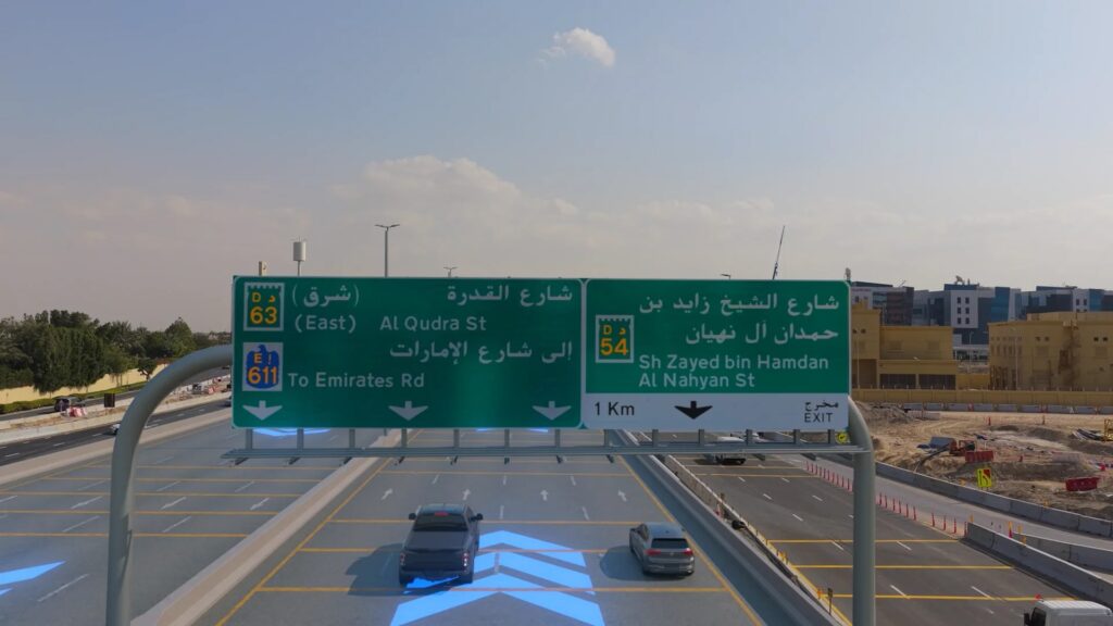 منظر جانبي لجسر حديث متعدد المسارات عند الغسق، مع مرور السيارات أسفل أعمدة الدعم الخرسانية.