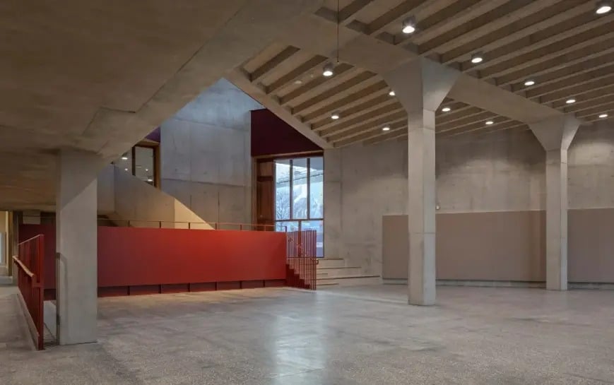 Interior of the expansive design studio featuring 30-meter timber trusses and natural lighting at the new university facility.