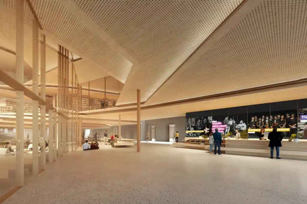 Spacious interior lobby of the Spiral Library featuring terrazzo flooring, perforated timber ceilings, digital screens, and glass partitions.